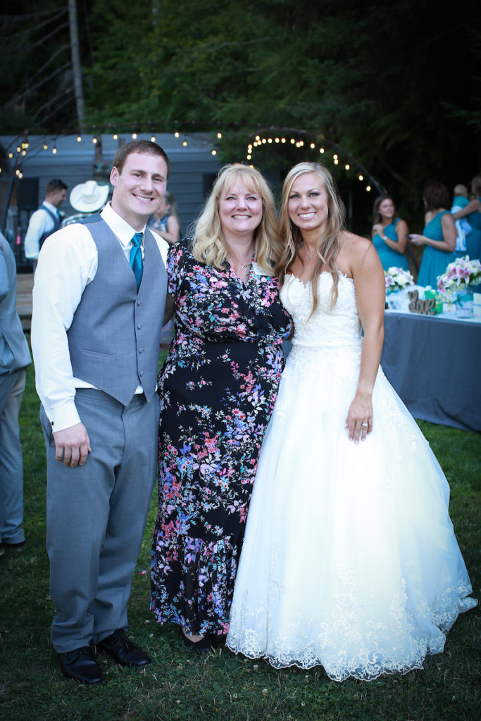 Carole poses with the bride and groom.