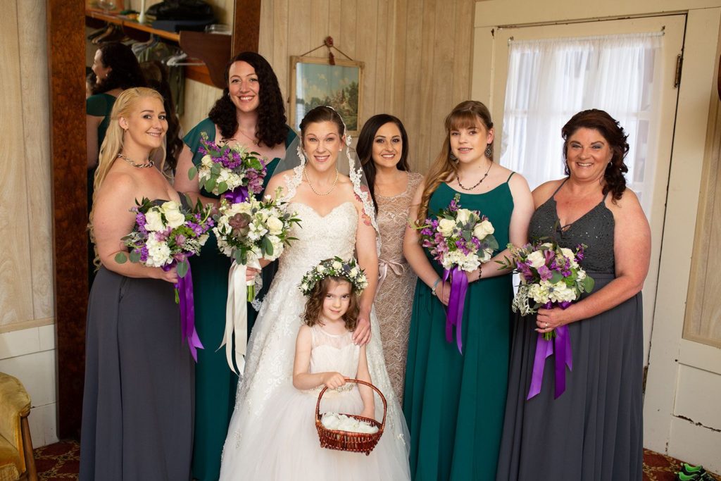 Female family of the bride poses for a photo in the bridal room.